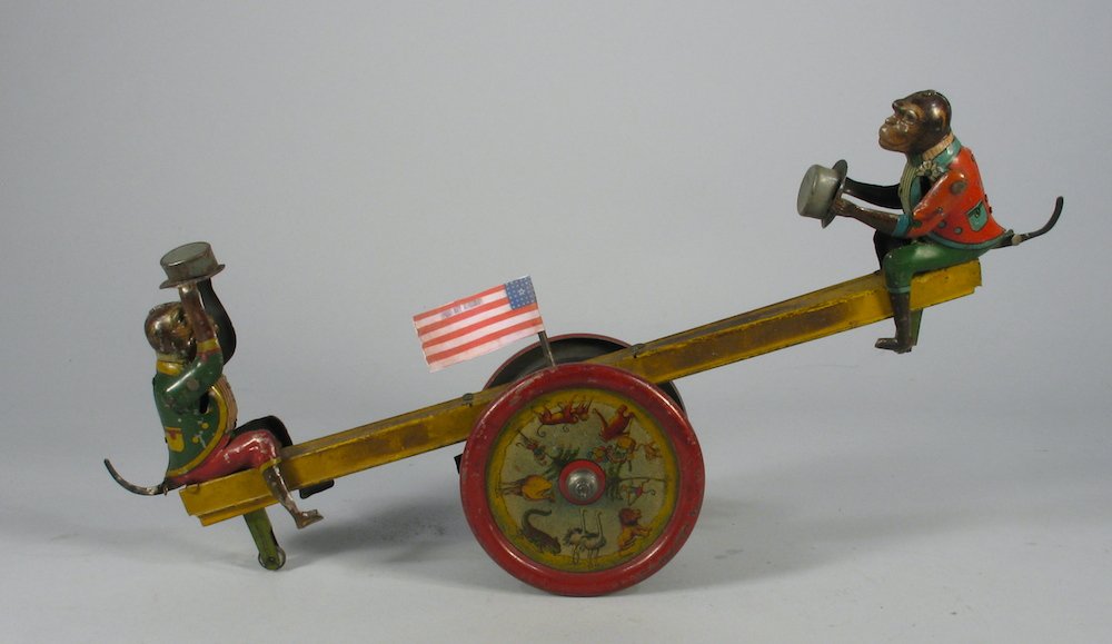 Distler German Wind Up Monkey See-Saw: Distler German tin toy monkey see-saw, monkeys put hats on as it goes up and down. c. 1920s working wind up toy. Toy measures 11 inches wide. One monkey missing wheel, replaced flag.
