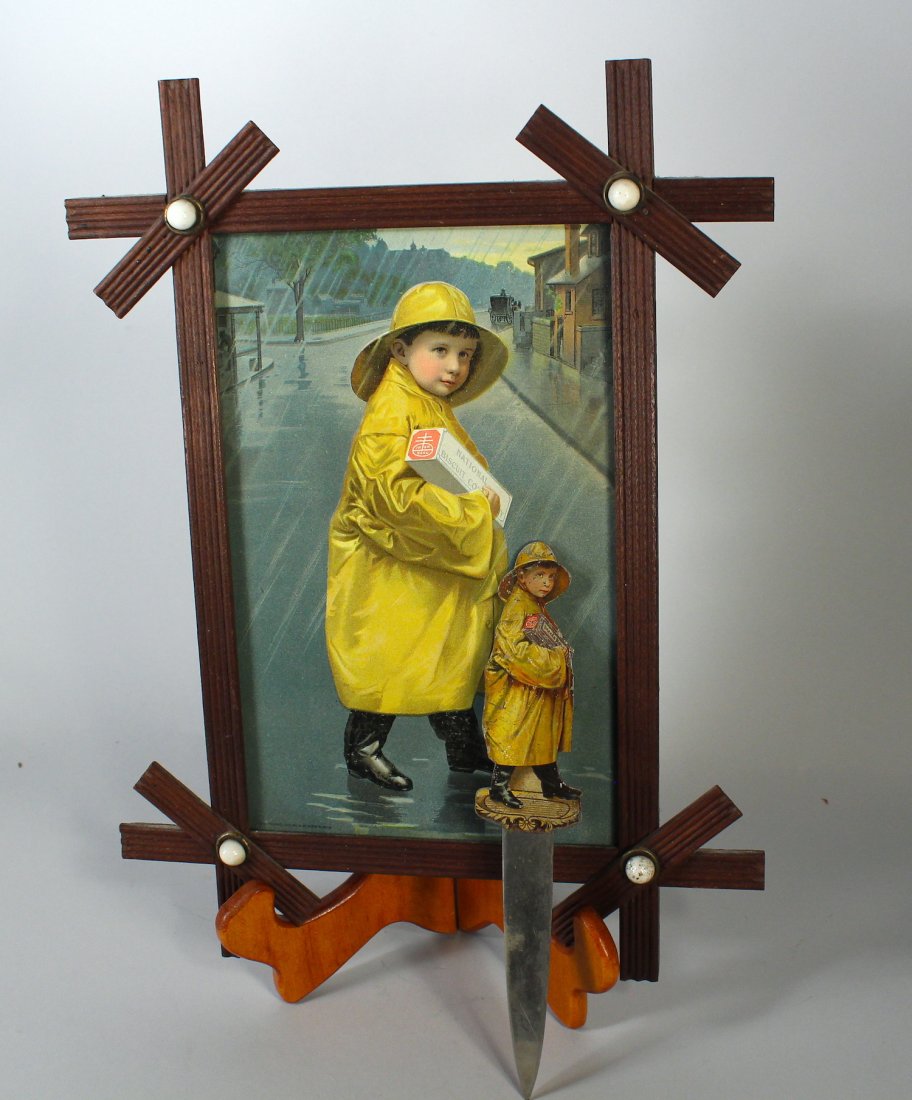 National Bisquit Co Framed Poster and Letter Opene: National Bisquit Co Framed Poster and Letter Opener. Nabisco framed iconic boy in raincoat with brass letter opener.