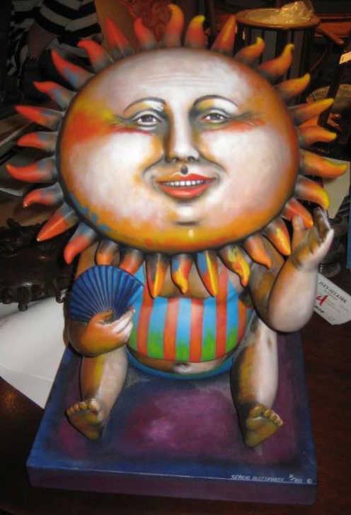 SERGIO BUSTAMANTE (B.1942): Painted ceramic figure seated with a sun form face, on canvas lined base, signed and numbered16/100. 14 1/2 inches