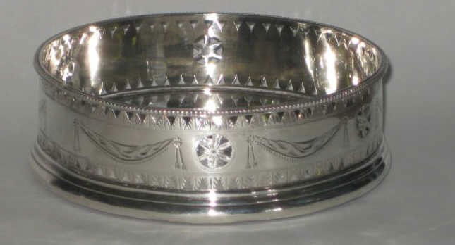 HESTER BATEMAN, LONDON, 1788: George III silver wine coaster with chased and pierced in Adam style gallery, silver bottom and turned mahogany support, hallmark bottom and rim. 1 1/2 x 4 5/8 in, total weight 5.7 troy ounces (includ