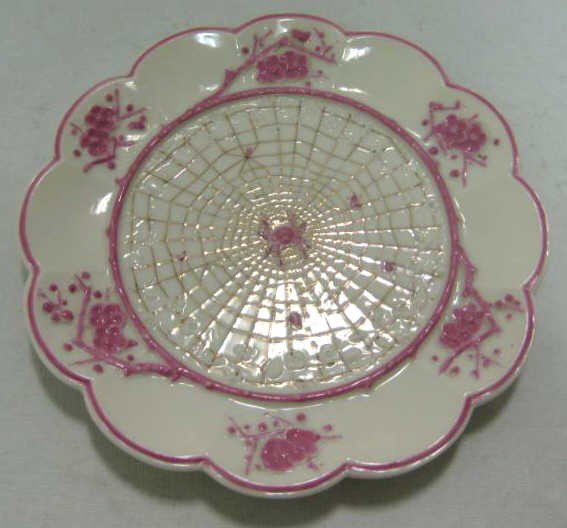 ANTIQUE IRISH BELLEEK PORCELAIN PLATE: "Thorn and Spider" pattern, molded design, pink enamel and gilded highlights, bearing 1-st printed black and impressed marks and two impressed British Registry marks, 1893-1890. Diameter 6 7/8 in.