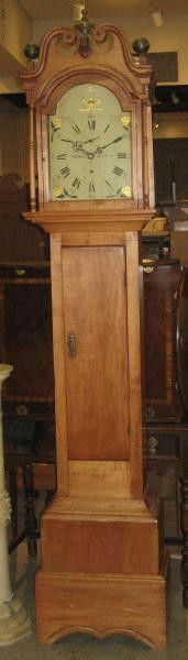 AMERICAN 19TH CENTURY TALL CASE CLOCK: Broken arched pediment covers the wooden arched dial marked "THOMAS & HOADLEY", hand painted with floral bouquets, with second subsidiary dial, wooden works all over the long door with separate layere