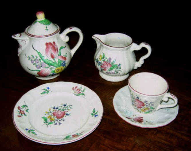 FRENCH KELLER & GUERIN, LUNEVILLE POTTERY SET: Assembled service in "Old Strasbourg Tulips and Rose" pattern comprising 3 dinner plates, 3 soup bowls, 9 soup plates in two sizes, 9 shaped rimmed salad plates, 12 smooth rimmed salad plates, 23 cups
