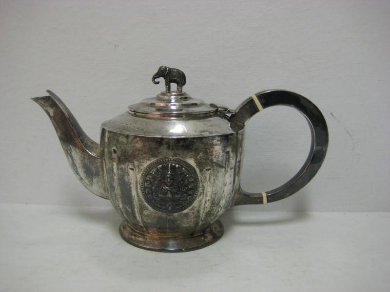 THAI NAKON, SIAM, STERLING SILVER TEAPOT: The partially fluted body applied with two relief Buddha rosettes, a hinged lid has elephant-form finial, marked. 5 1/4 x 8 7/8 x 4 1/4 in; weight 10.6 troy ounces.