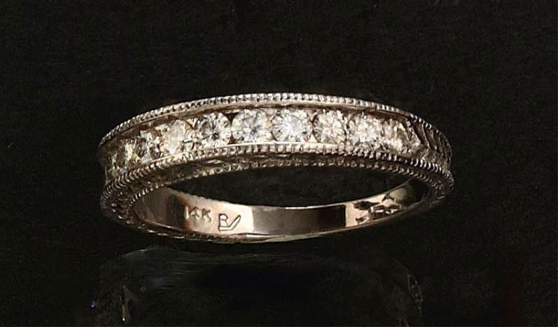 WEDDING RING: 14k white gold band with vintage beaded border style set with twelve round faceted stones (not diamonds). 4 grams. Size 8 1/4.