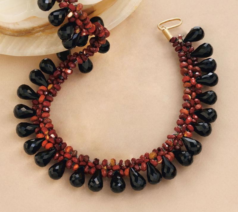 ONYX AND CARNELIAN NECKLACE: Faceted carnelian beads woven in a mesh necklace with faceted briolette-cut pear shaped onyx. 17 inches.