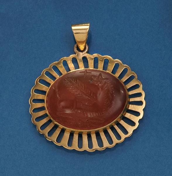 CARNELIAN PENDANT: 18k yellow gold pendant with one oval carnelian carved with a winged creature. Carnelian measures 19mm x 15mm. 4.2 grams