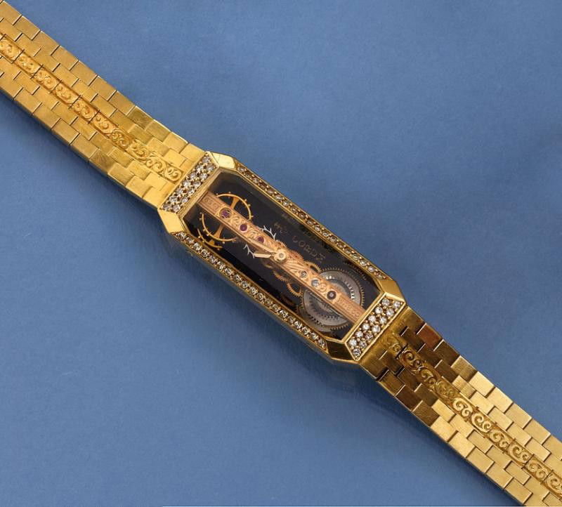 DIAMOND WATCH CORUM: 18k yellow gold lady's watch with rectangular shape, skeleton dial with golden bridge movement at center and Corum link bracelet with 18k yellow gold with Corum Key signed clasp. Watch has manual wind