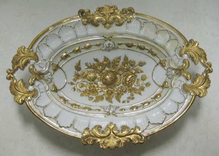 MEISSEN PORCELAIN OVAL DISH: Gilt floral relief in the center, applied oak leaf on rim and handles, repaired, 'pommel crossed swords' mark, 19th century. 2 5/8 x 14 x 10 1/4 in.