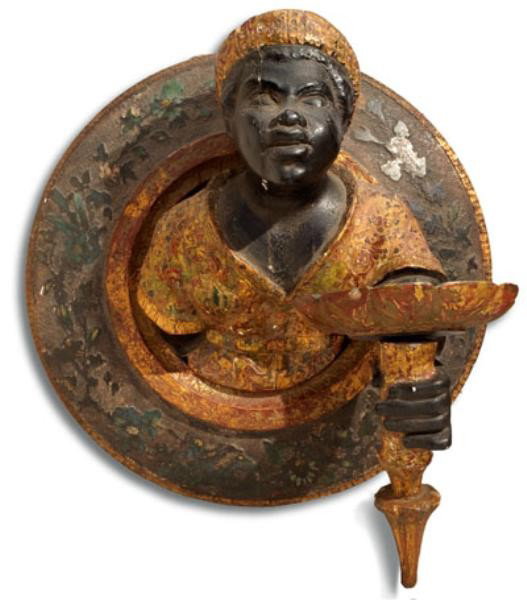 CONTINENTAL BLACKAMOOR FIGURAL WALL SCONCE: Carved chest length figure of a man, protruding from the foliate and bird carved circular plaque, the figure with one hand out holding a foliate dish, polychrome decorated. Diameter 16, depth 12 1/2 i