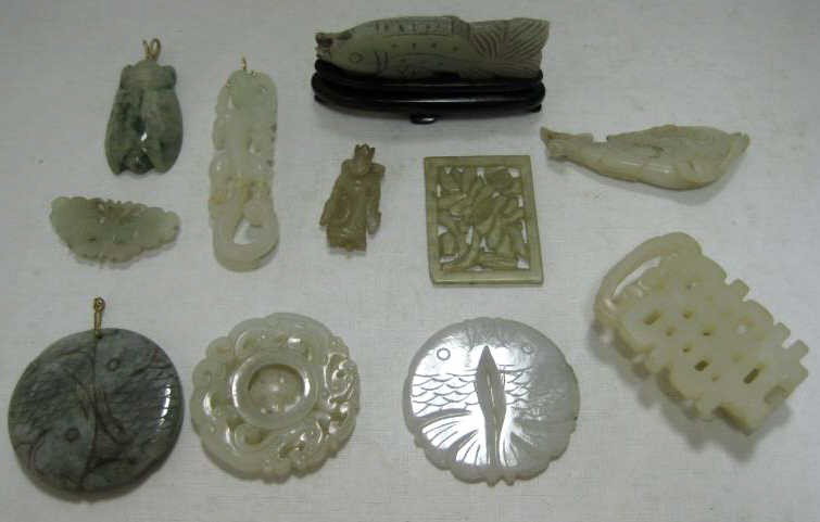 TWELVE JADE MINIATURE CARVINGS: White and green, comprising three round discs, one with openwork of two dragons and movable center in form of Wan and two pendants with fish motifs (d: 2"-3"), rectangular pierced floral plaque (2 x 1