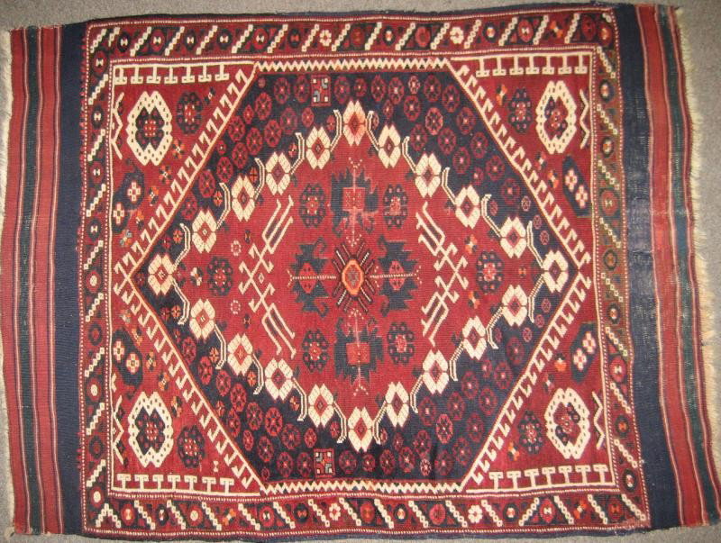 TURKISH BERGAMA THROW RUG: Geometric and floral decorated red medallion to the navy field, red spandrels, multiple borders. 3 feet x 4 feet