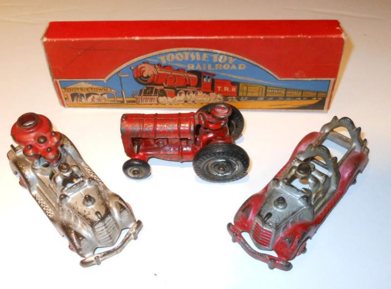 ARCADE, HUBLEY AND TOOTSIE TOY: Four pieces; Arcade cast iron toy tractor #2736, l. 3 1/2 in.; two Hubley cast fire engines, no wheels, l. 4 7/8 in.; and a boxed Tootsie Toy Railroad, missing one car.