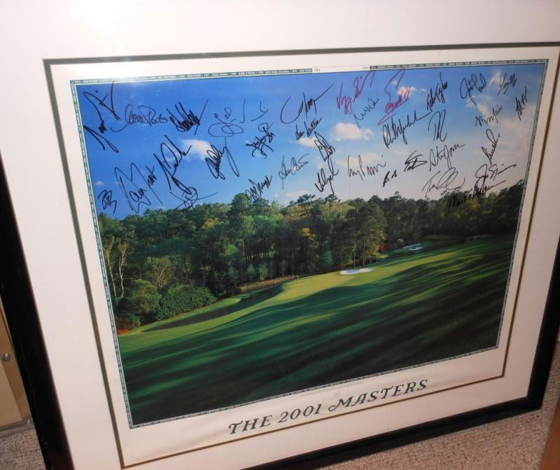 "THE 2001 MASTERS" AUTOGRAPHED POSTER: Showing the "11th Green and 12th hole at Augusta National Gold Club", approximately 34 autographs through the sky, framed.