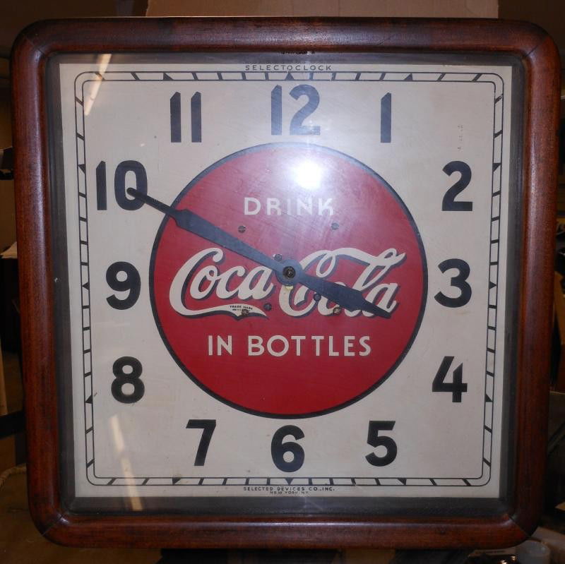 COCA-COLA 1940 WOODEN FRAMED WALL CLOCK: Square, by Selected Devices Co., Inc., red "DRINK COCA-COLA IN BOTTLES" to the center, glass front, 16 in.