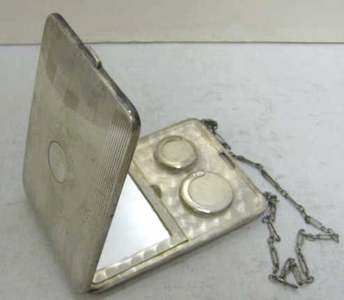 HALLMARK SILVERSMITHS, INC., NEW YORK, NY: Sterling silver rectangular compact box containing a clip on gilt hinged lid and on the other side mirrored powder box and two coin holders, with mounted silver chain, 20th century. 3 1/2 x 2 3/8 in; 