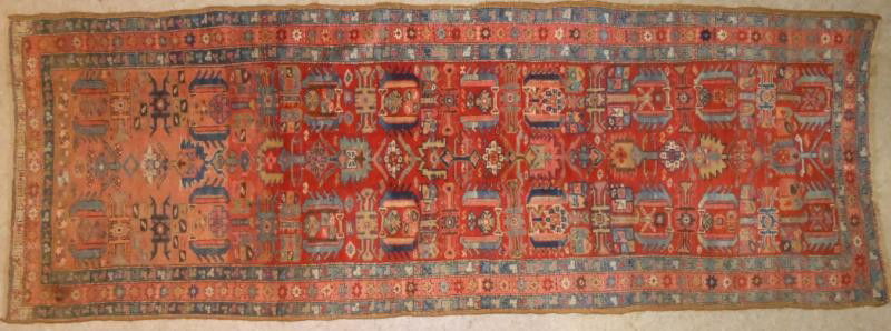 ANTIQUE BAKHSHAISH LONG RUG: Colorful geometric medallions to the red field, red border with blue guard borders, wool foundation, circa 1900. 3 ft. 10 in. x 10 ft. 6 in.