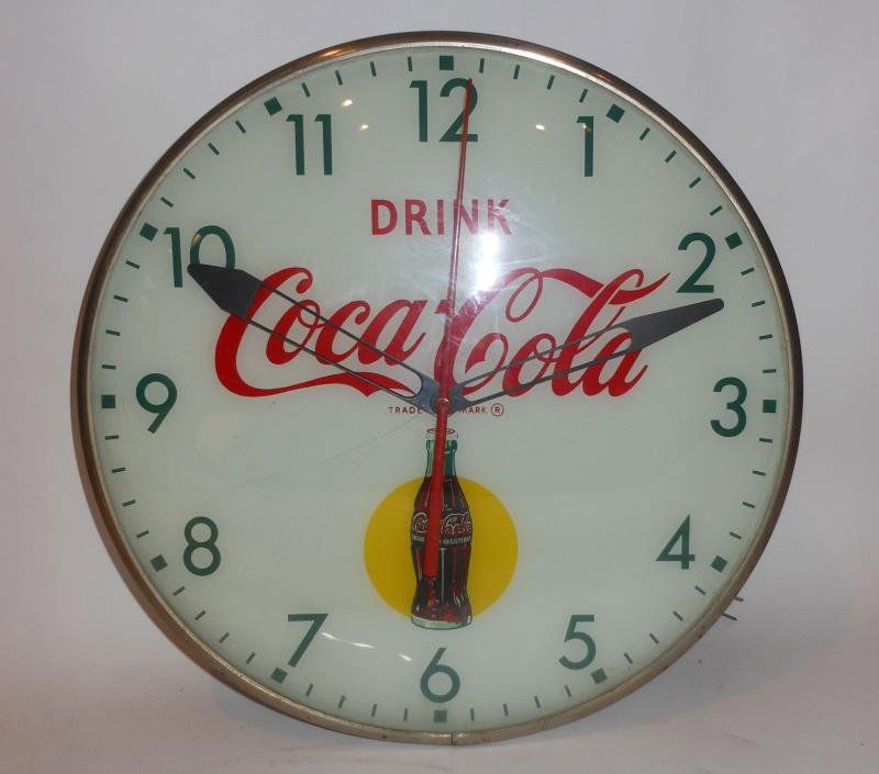 COCA-COLA WALL CLOCK: "Drink Coca-Cola" circular clock with spotlighted Coke bottle at 6 o'clock, green numbers, 1950s or earlier.