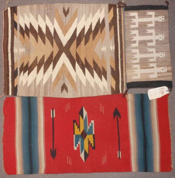 THREE NATIVE AMERICAN WOOL WEAVINGS: Yei sample having Teec Nos Pos label, 10" x 19 1/2", (Susie Jones #8) hand written on label, serrated diamond and arrow design rug, 21" x 28" and a banded Navajo with arrow and geometric decoration, 1
