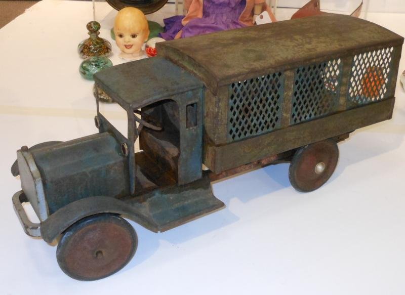 PRESSED STEEL TOY TRUCK: Likely Buddy L, with screen sides to the covered bed, full cab with driver side flag, length 26 1/2 in.