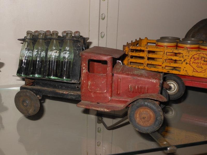PRESSED STEEL DELIVERY TRUCK WITH 8 COKE BOTTLES: Likely a Metalcraft, with no marquee above the 8 half full miniature Coke bottles to the back rack, Goodrich Silvertown wheels on front, Kingsbury wheels on back, rough, 9 3/4 in.