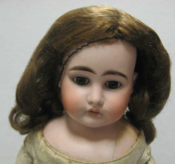 22" ERNST HEUBACH OF KOPPELSDORF DOLL: Bisque shoulder head, Jumeau style face with open mouth and glass eyes on kid leather body, horseshoe mark, mold #1900, repaired shoulder.