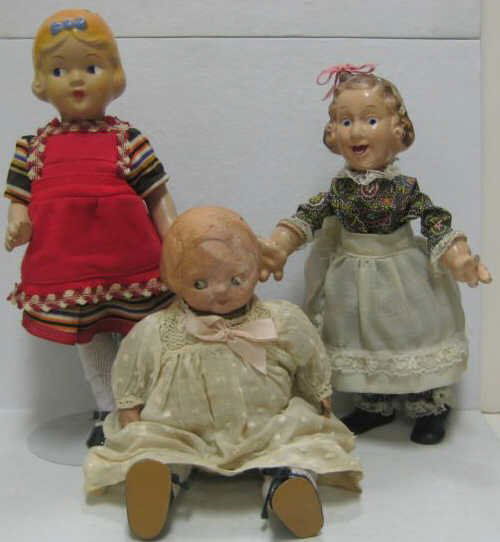 THREE COMPOSITION CHARACTER DOLLS: All composition with molded hair and bow, painted, on five-piece child body, H: 14"; Swiss Bucherer style girl, composition head and large hands, molded bobbed hair and loop for tying on a ribbon, woo