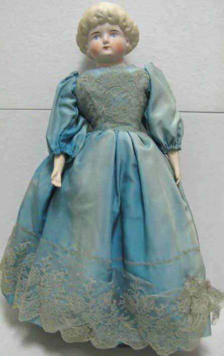 20 1/2" GERMAN PARIAN BISQUE SHOULDER-HEAD DOLL: Molded blond hair, painted feature, cloth body, bisque arms and legs with heeled boots, # 6 impressed on plate, wearing blue silk dress.