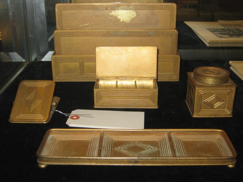 TIFFANY STUDIOS, NEW YORK: GRADUATE PATTERN, a five-piece bronze desk set: letter holder, pen tray, ink well, stamp box and clip.