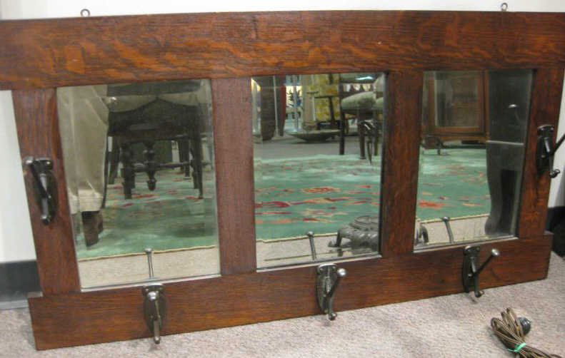 ARTS AND CRAFTS WALL MOUNTED COAT RACK: Oak frame with three beveled edge mirrors, five metal hooks.