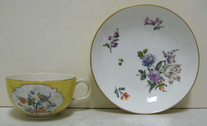 MEISSEN PORCELAIN CUP AND SAUCER: Yellow grounded cup with two painted reserves of 'Indian Flowers' together with matching saucer of later date, each bearing crossed swords with star below mark underglaze blue, 18th/19th. Cup: 1 7/8 x