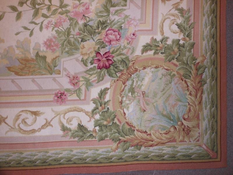 NEEDLEPOINT ROOM RUG: Rose filled flowering branches decorate the ivory field, scrolling borders with landscape medallions at the corners. 10 ft. x 14 ft.