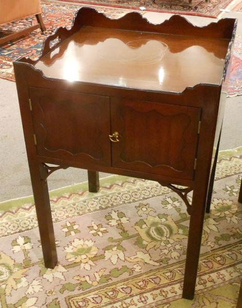 GEORGIAN STYLE MAHOGANY SIDE CABINET: By Kittinger, with rolling gallery showing handle holds to the top, pair of cupboard doors, pierced brackets a top the square legs (CW57). Height 31, width 21, depth 19 1/4 in.