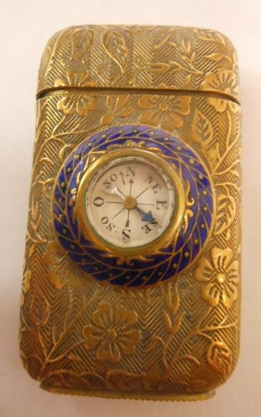 BRASS & COMPASS MATCH SAFE: Gilt foliate design allover, blue enamel framed compass to one side, 1 1/8 x 1 7/8 in.