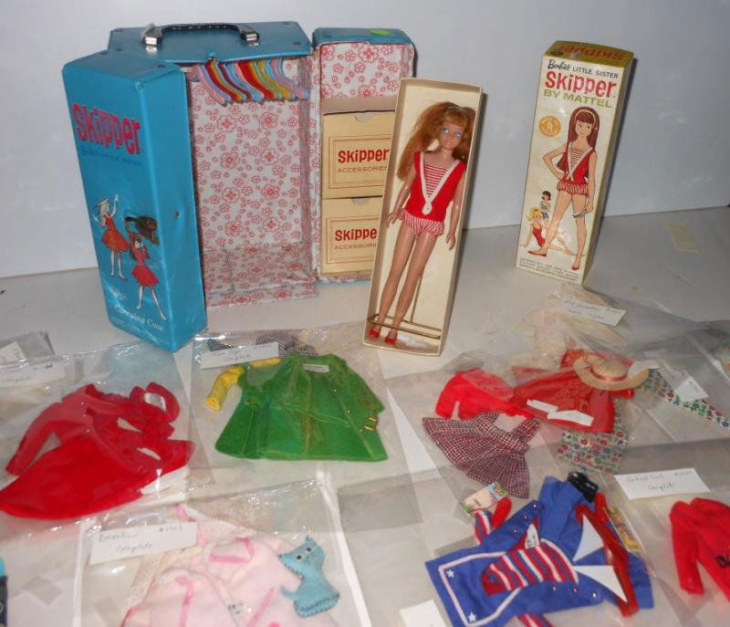 BARBIE SKIPPER DOLL #950 WITH ACCESSORIES: Circa 1964-1965, Titian with one piece red and white swimsuit, red flats, brush and comb and detached wrist tag, together with blue Skipper carrying case and a collection of Skipper outfits consisting