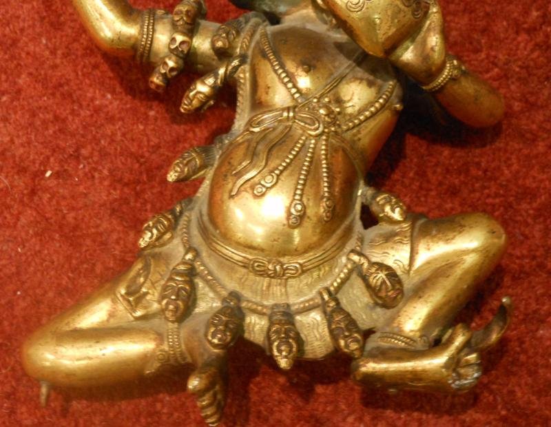 CHINESE GILT-BRONZE LEAPING FIGURE, 18TH CENTURY: the airborne figure with headdress and beard gazing upwards and holding a vessel with fire, embellished with multiple chains and jewelry suspending miniature heads over a finely patterned loin garment