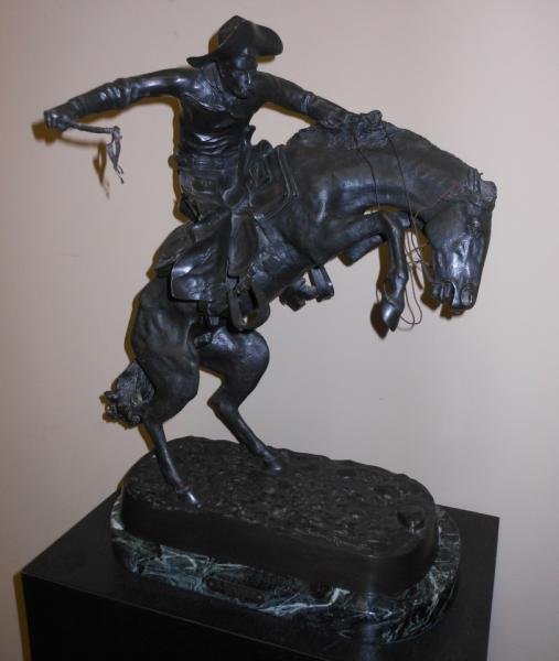 AFTER FREDERIC REMINGTON, "BRONCO BUSTER,": on green to white marble base and later black pedestal.