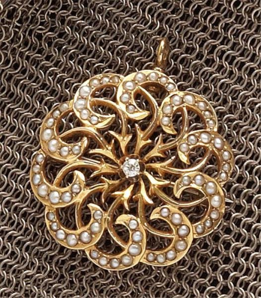 VINTAGE PEARL AND DIAMOND PENDANT/BROOCH: 14k yellow gold starburst brooch set with one old European cut diamond weighing .05ct. surrounded by seed pearls in a swirl design. Brooch has a hidden hinged swivel bale. 1 1/8 inch diameter. 4.7 gra