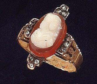 CAMEO AND ROSE CUT DIAMOND RING: 14k yellow gold ring set with one carnelian cameo measuring 11.5mm x 7.5mm with ten rose cut melee diamonds (two deficient) Size 4. 3.8 grams.