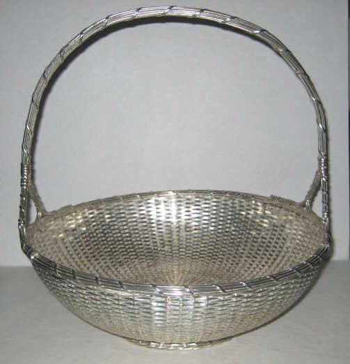 CHRISTOFLE, PARIS, FRANCE: Plated silver woven basket with upright handle, impressed mark, circa 1935-1983. Height 12 1/4 in, diameter 12 in. Purchased: Jules Pass Antiques, St. Louis. 12 1/4 x 12 inches