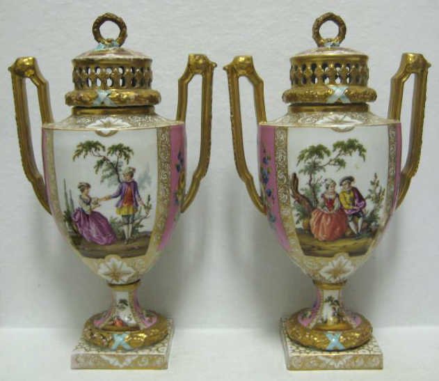 PAIR OF GERMAN PORCELAIN URNS: Hand painted two romantic scenes and floral medallions on white or pink ground, decorating marks of Helena Wolfsohn, Dresden, 19th century. Height 12 in.