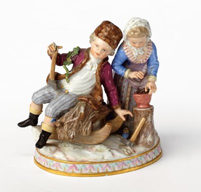 MEISSEN PORCELAIN SEASONAL CHILDREN GROUP: Allegorical of Winter, sitting boy on a sled and standing girl, on oval base, mold G.94, designed by Schonheit, 19th/20th century, imperfection to one axe ending. Height 5 1/2 in.
