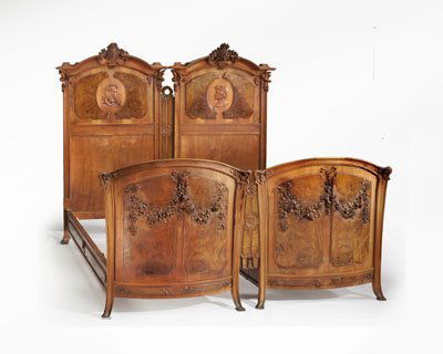 PAIR ANTIQUE CONTINENTAL ART NOUVEAU BEDSTEADS: Arched headboards with elaborate carved floral crest over profile portrait medallions, with matching convex foot boards showing carved ribbon and festoon highlights, side rails with later extensions,