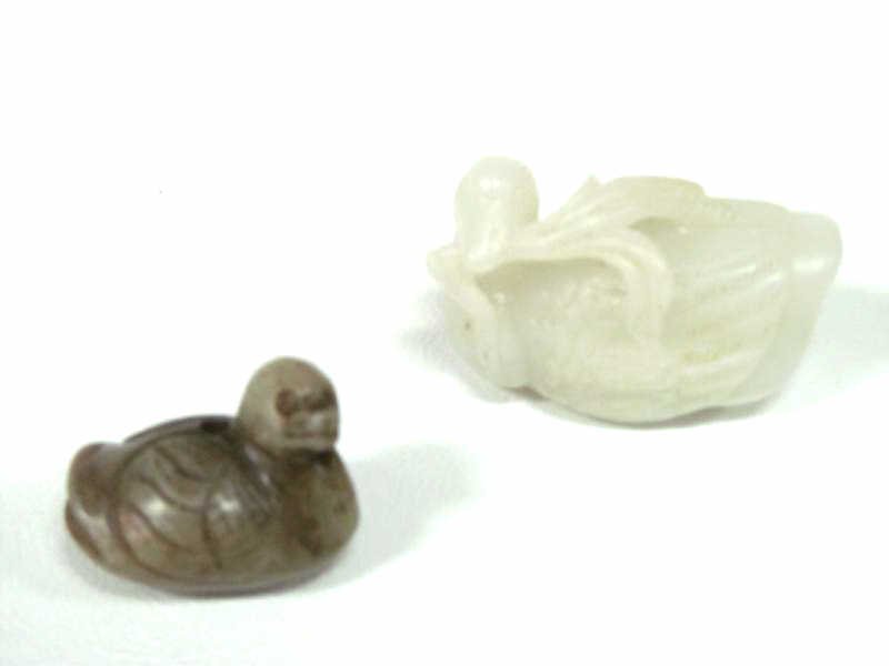 TWO CHINESE SCULPTED MINERAL DUCKS: Pale green with foliage in beak, 1 1/2 x 2 inches; and green with brown, drilled, 1 1/4 x 1 1/2 inches
