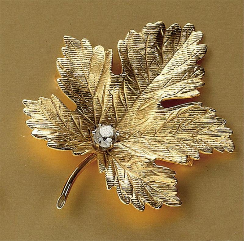 DIAMOND BROOCH: 14k yellow gold hand engraved oak leaf set with one old mine cut diamond weighing .33ct. 1 1/16 inches x 1 1/2 inches. 6.6 grams.