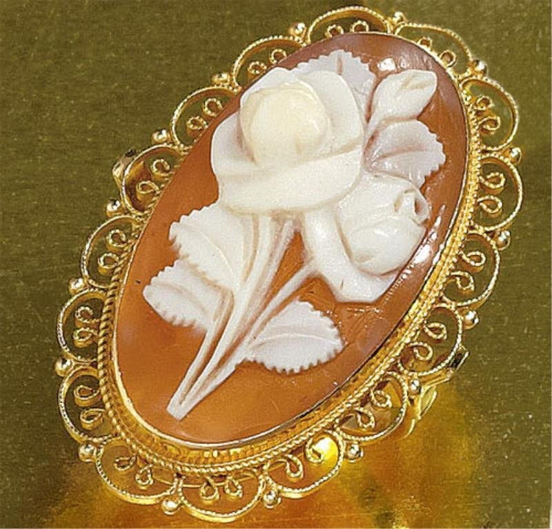 CAMEO RING: 14k yellow gold ring with a carved rose shell cameo measuring 1 1/8 inches x 5/8 inch. Cameo is set win a scalloped filigree bezel. Size 6 1/2. 5 grams.