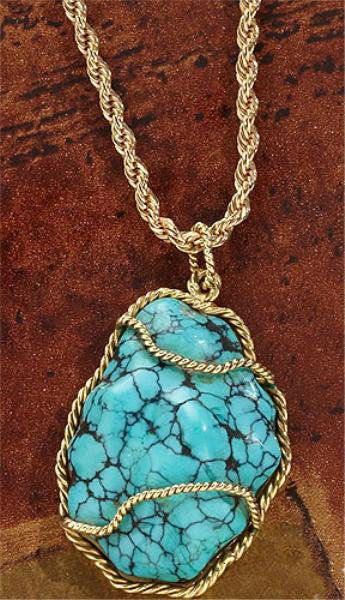 TURQUOISE PENDANT: 18k yellow gold pendant with twisted gold borders and polished frame set with one polished, veined turquoise measuring 1 1/2 inches x 1 inch. Pendant is suspended on a gold filled rope chain. 19 grams