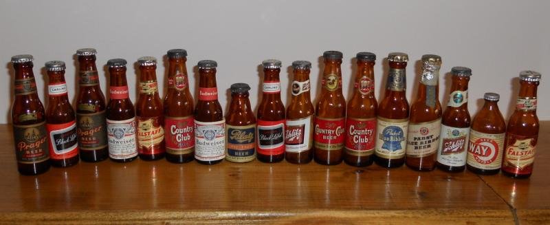 COLLECTION OF MINIATURE BOTTLE FORM SHAKERS: Vintage pieces, with labels of Budweiser, Falstaff, Country Club, Schlitz, Black Label, Blatz, Pabst and more.