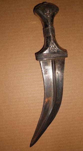 ANTIQUE SILVER MUGHAL DAGGER: Foliate decorated grip, to the curved blade, length 10 1/4 in.