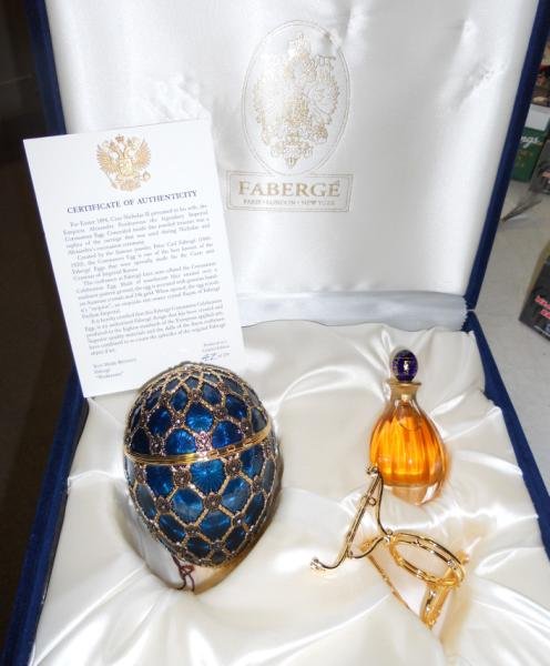 FABERGE REPRODUCTION CORONATION EGG: A limited edition 47/250, the egg approximately 5 1/4" high, is decorated in translucent blue enamel over a sunburst-pattern ground, in a fitted blue velvet box with original 1 oz. bottle of perfume.